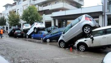 Le auto accatastate in via della Resistenza; don Giovanni Perini al lavoro nel fango e San Caprasio danneggiata dalla piena