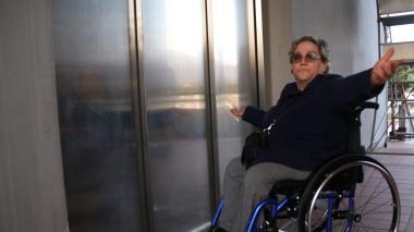 A sinistra la signora Bruna Toria davanti all’ascensore guasto a destra gli scalini invalicabili per un disabile