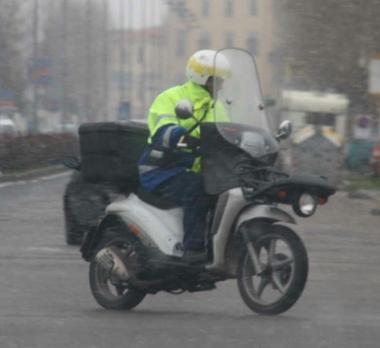 Un portalettere al lavoro con lo scooter    