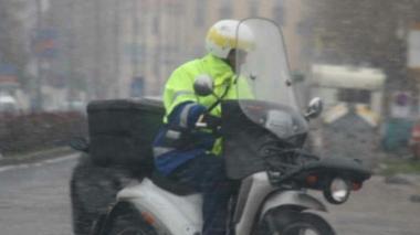 Un portalettere al lavoro con lo scooter