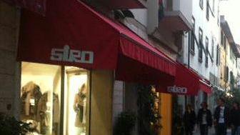 Sopra il negozio “Siro” in via Roma; accanto il cartello alla boutique in via Verdi