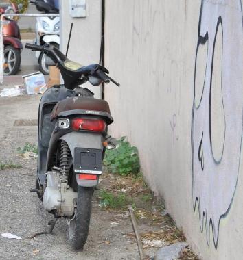 Un motorino senza targa e semi distrutto abbandonato nella zona portuale