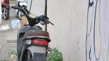 Un motorino senza targa e semi distrutto abbandonato nella zona portuale