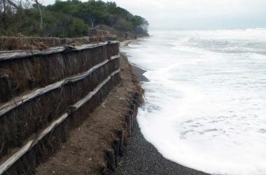La spiaggia di Perelli sommersa dal mare e a destra un surfista che approfitta delle onde e il porto di Piombino rimasto chiuso per tutto il giorno 