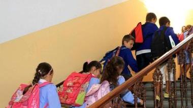 L’assessore all’istruzione Ennio Rucco e, a destra, alunni fanno il loro ingresso a scuola