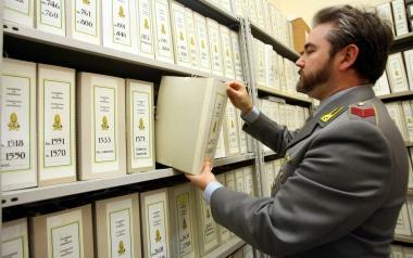 Sopra: un finanziere al lavoro in archivio per i controlli. Nel riquadro in alto: la compilazione della dichiarazione dei redditi