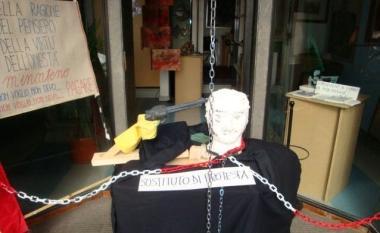 Protesta contro il Fisco incatenando una statua