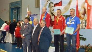 <b>LOTTA</b> Fabrizio Mainardi sul podio mondiale a Tirana e, qui a fianco, insieme al comandante Frezza