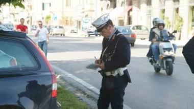 Un vigile mentre scrive un verbale di multa (archivio)