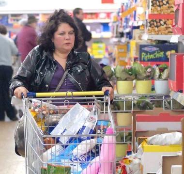 La spesa con il carrello fra gli scaffali di un supermercato 