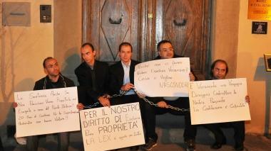 I componenti della famiglia Festari insieme al loro consulente incatenati per protestare per la mancata consegna dell’eredità
