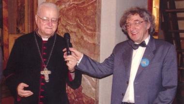 Il vescovo Simoni insieme a don Faldi, sotto la copertina del libro 
