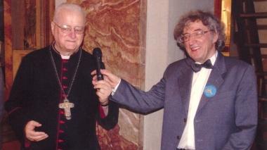 Il vescovo Simoni insieme a don Faldi, sotto la copertina del libro