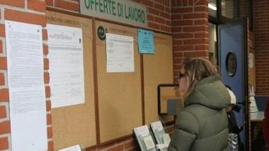 Una ragazza controlla gli annunci di lavoro in un centro per l’impiego e sotto Giovanni Occhipinti