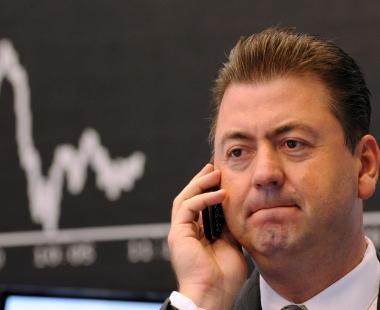 Da sinistra: un operatore di borsa preoccupato per landamento dei mercati e la cassa di una banca 