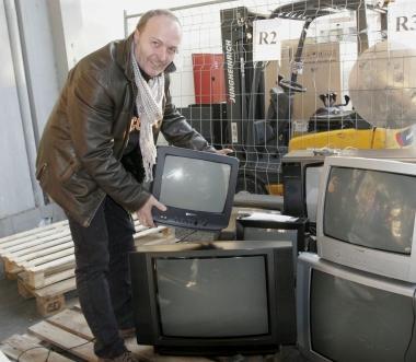 Patrizio Pesaresi mostra i televisori da smaltire 