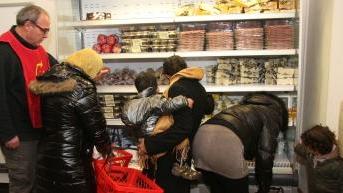 Consegna di beni alimentari e di prima necessità in un emporio della Caritas
