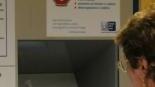 Una signora mentre paga il ticket alla macchinetta automatica