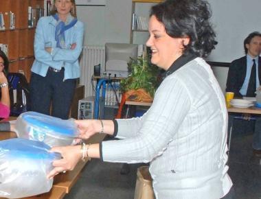 A sinistra la consegna delle stoviglie di plastica alle scuole Raffaello       