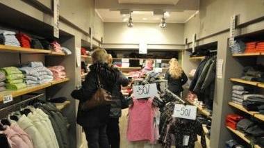 Sotto il presidente Enzo Nigi e accanto un interno di un outlet che vende abbigliamento