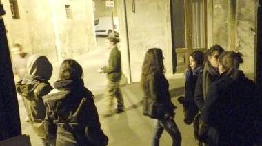 A fianco alcuni studenti di “Occupy Pisa” in via la Pergola all’ingresso del palazzo occupato. A destra uno striscione degli studenti