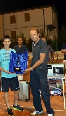 In alto Nicola Agostini e qui mentre premia uno dei vincitori del torneo di tennis dedicato alla memoria del padre Arnaldo 