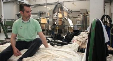 Un operaio sulle pezze di Fin Mode nel giorno della chiusura e sopra lesterno della tintoria 
