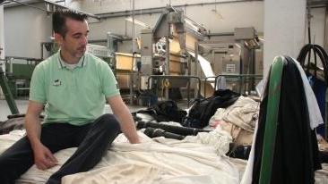 Un operaio sulle pezze di Fin Mode nel giorno della chiusura e sopra l’esterno della tintoria