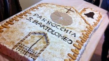 In alto la chiesa da restaurare Accanto la torta in onore della parrocchia di San Bartolomeo