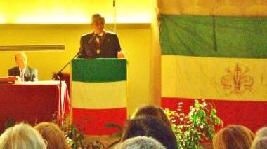 Un momento dell’intervento di Vaglini e, a destra, il tricolore esposto