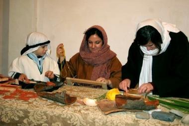 Delle figuranti allopera con antichi mestieri in un presepe vivente 