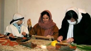 Delle figuranti all’opera con antichi mestieri in un presepe vivente