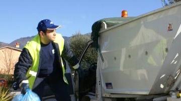 Un addetto alla raccolta rifiuti con il furgoncino elettrico