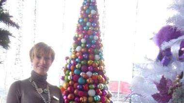 Daniela Salvadori nel suo negozio davanti ad una sua creazione di albero di Natale