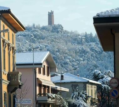 Uno scorcio invernale di San Miniato con la Rocca innevata; pi&ugrave; a destra un cittadino intento a spalare 