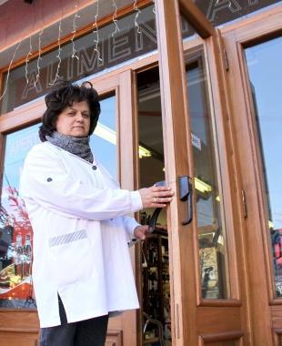 Annalisa Domenici mostra la porta della sua alimentari scassinata dai ladri 