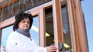 Annalisa Domenici mostra la porta della sua alimentari scassinata dai ladri