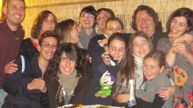 Foto di gruppo degli atleti intorno alla torta; sotto l’istruttrice Linda Vanni con i tre atleti medagliati