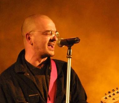 Sopra Danilo Sacco, a fianco i Nomadi in concerto 