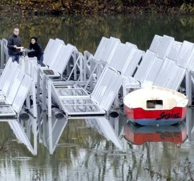 Un tecnico spiega il progetto, mentre in alto si possono vedere i pannelli sullacqua del laghetto 