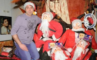 Sopra Roberto Casini con alcune delle sue creazioni A sinistra via della Madonna a Pistoia addobbata di Babbi Natale che s’arrampicano sui muri