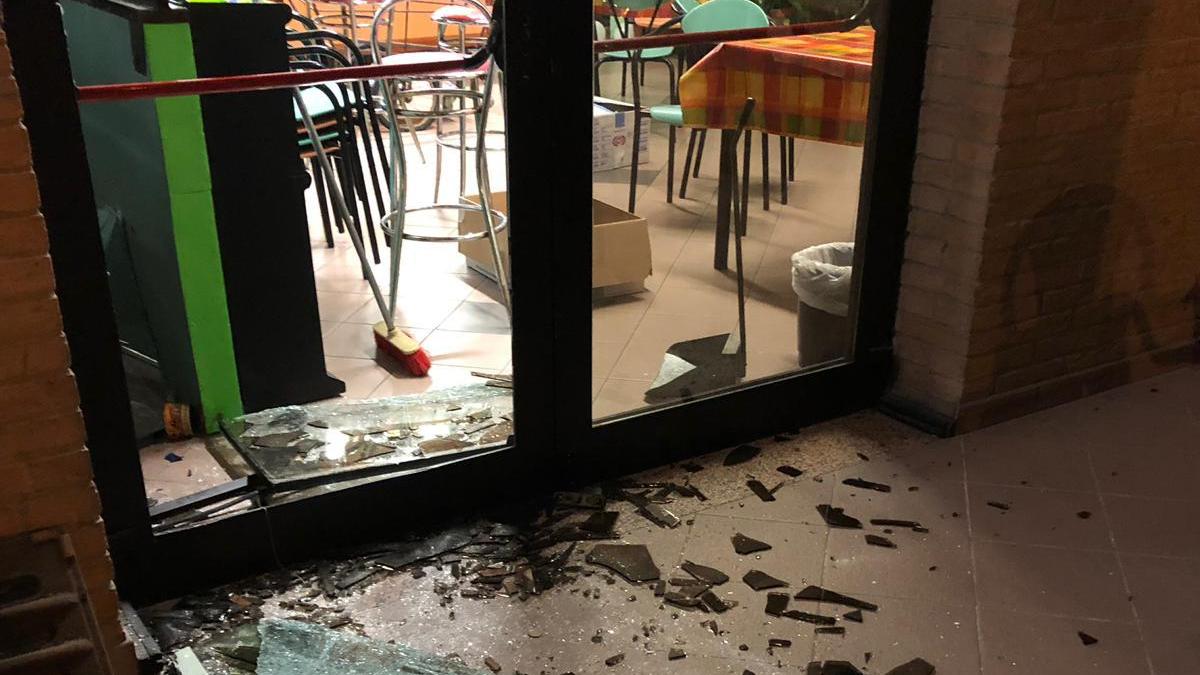 La vetrata del bar della bocciofila di Rubiera spaccato con un tombino (foto Rossi)