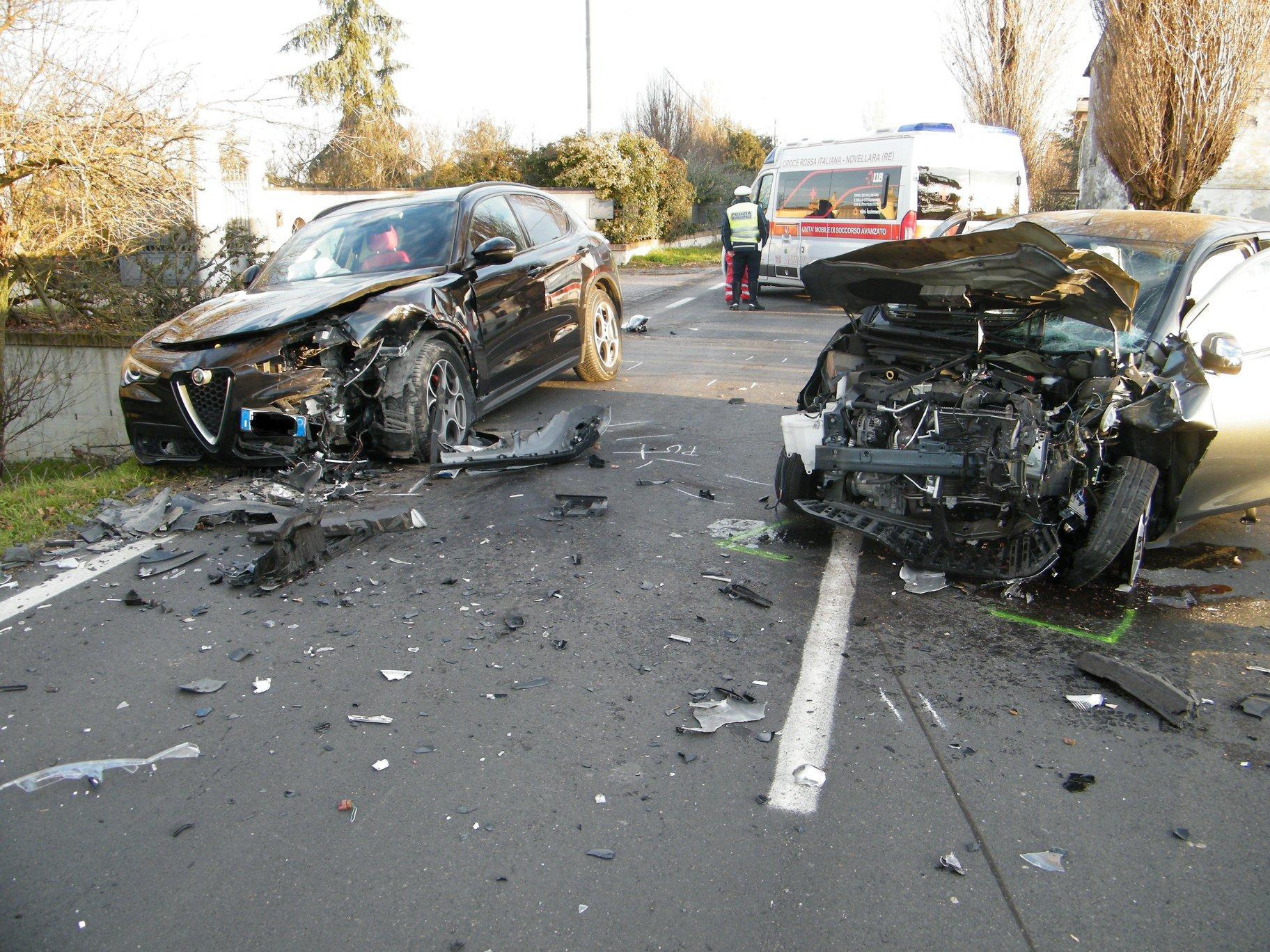 La Peugeot 108 e l'Alfa Romeo Stelvio che si sono scontrate frontalmente lungo la Provinciale Nord a Novellara e sullo sfondo la polizia muncipale Bassa Reggiana che ha rilevato l'incidente
