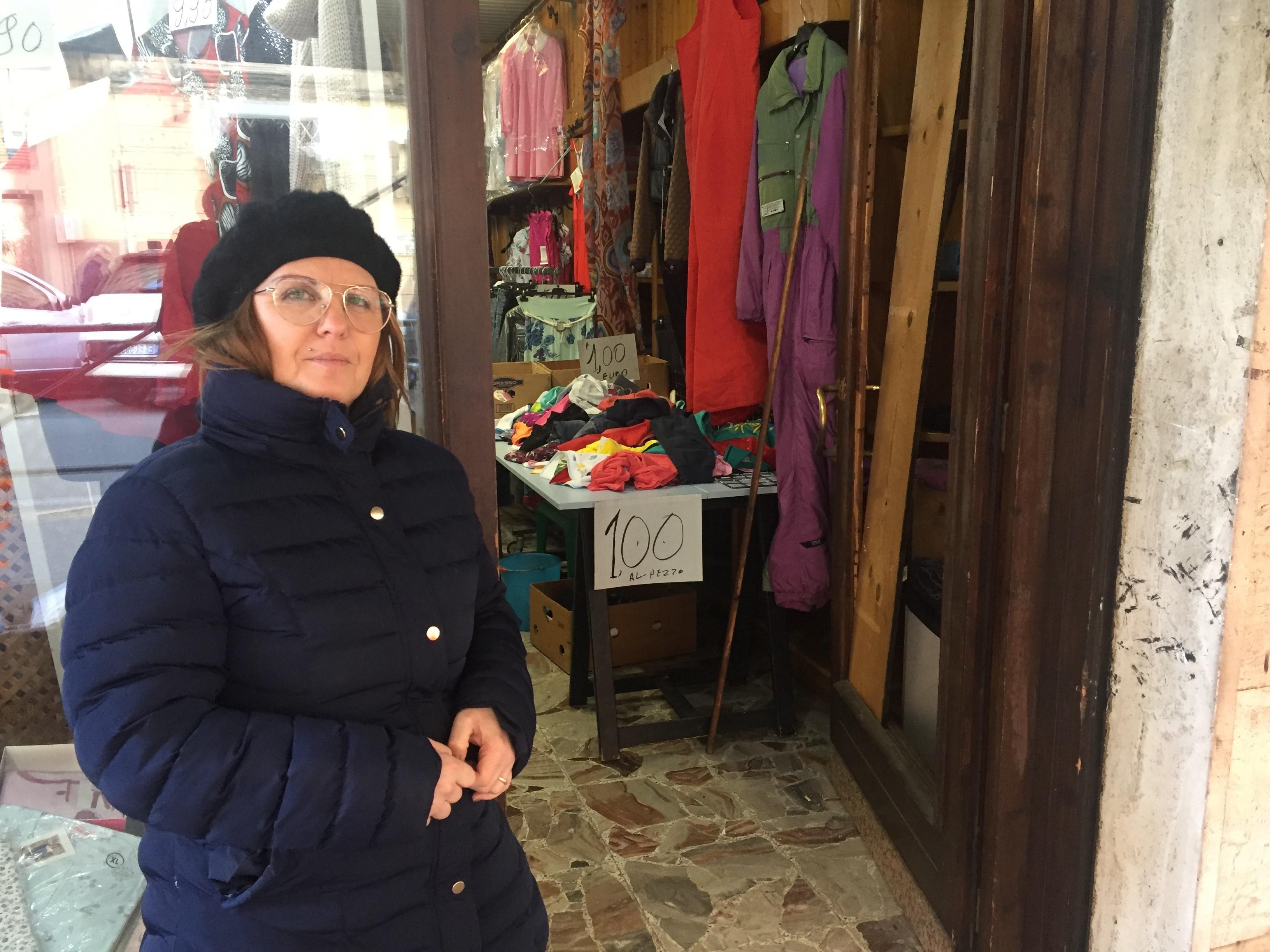 Francesca Bonelli davanti alla porta distrutta del suo negozio di abbigliamento