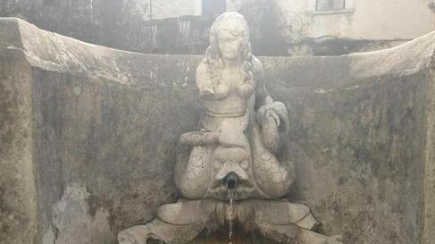 Armato di scopa tira a lucido e pulisce la fontana della Sirena