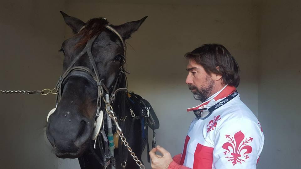 Riccardo Picchi nel box con il cavallo alle prese con la vestizione (briglie e finimenti)