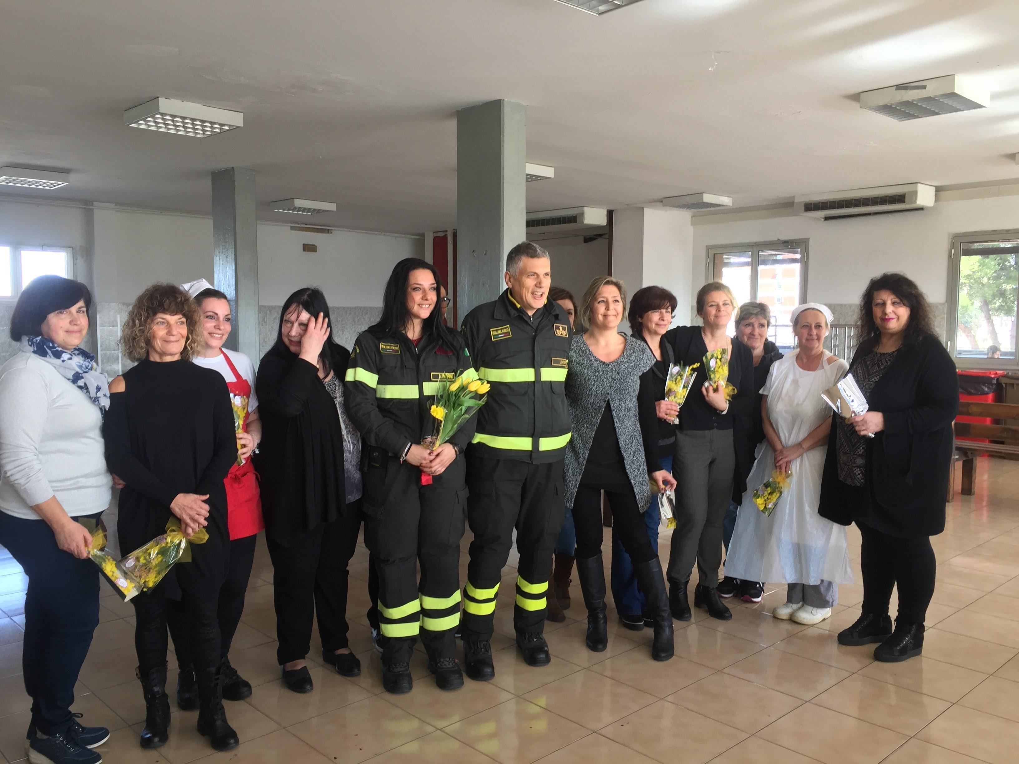 Foto ricordo dopo la consegna delle mimose al comando dei vigili del fuoco di Livorno: al centro, con la divisa, il comandante provinciale Alessandro Paola ed Eleonora Ricci