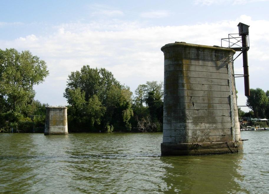I resti della passerella su cui negli anni Ottanta poggiavano le tubazioni dell’acquedotto di Livorno: quelle quattro pile (due nell’alveo e due nelle golene) verrebbero riusate per sostenere la nuova struttura