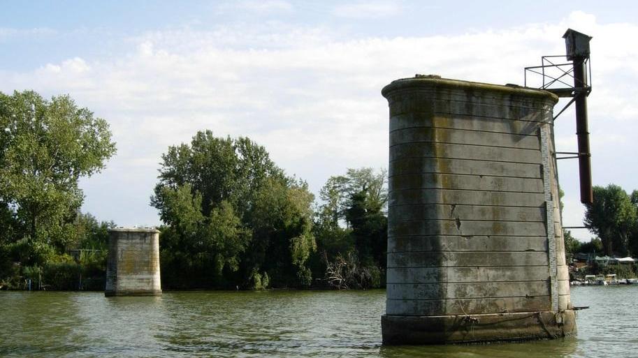 I resti della passerella su cui negli anni Ottanta poggiavano le tubazioni dell’acquedotto di Livorno: quelle quattro pile (due nell’alveo e due nelle golene) verrebbero riusate per sostenere la nuova struttura