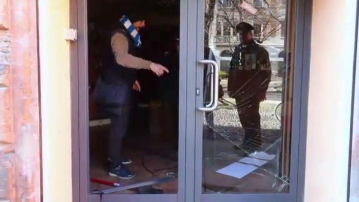 Proprietario e carabinieri davanti alla porta a vetri sfondata